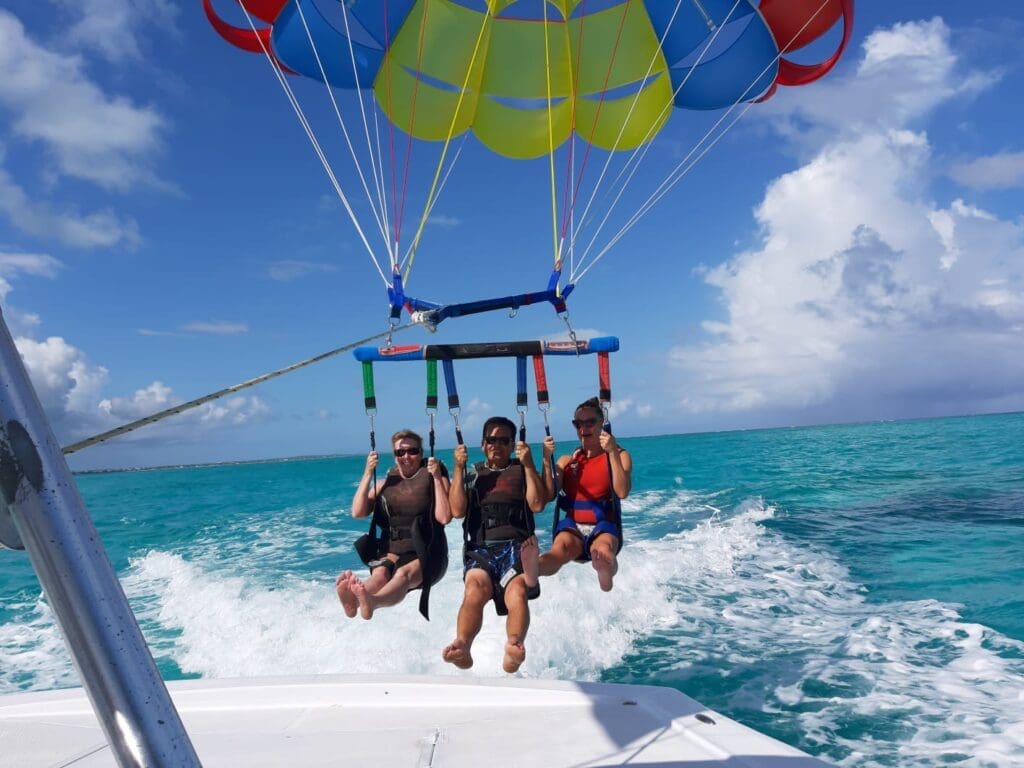 Family enjoying a parasailing boat trip in Grace Bay, Providenciales, Turks and Caicos with Captain Marvin's Watersports.